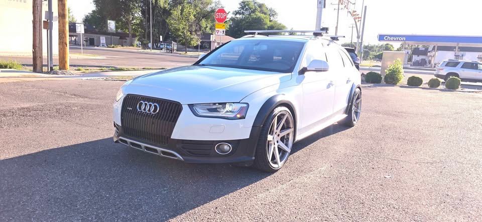 Silver Audi sedan parked on a sunny street, front view