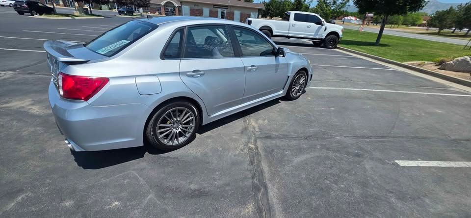 Silver sedan parked in an empty asphalt lot on a sunny day