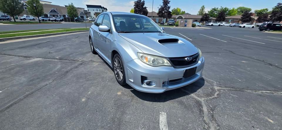 Silver sports sedan parked in an empty asphalt lot on a sunny day