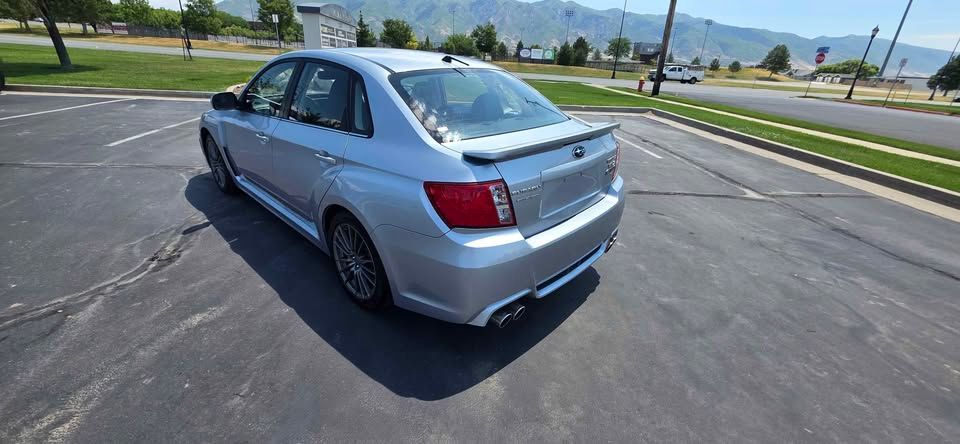 Silver sedan parked in an empty lot on a sunny day with mountains in the background