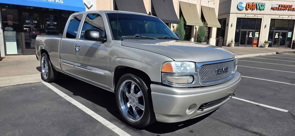 Silver pickup truck parked in a shopping center lot under awnings