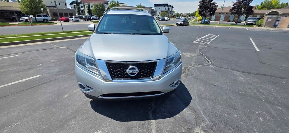 Silver Nissan SUV parked in an empty parking lot on a sunny day