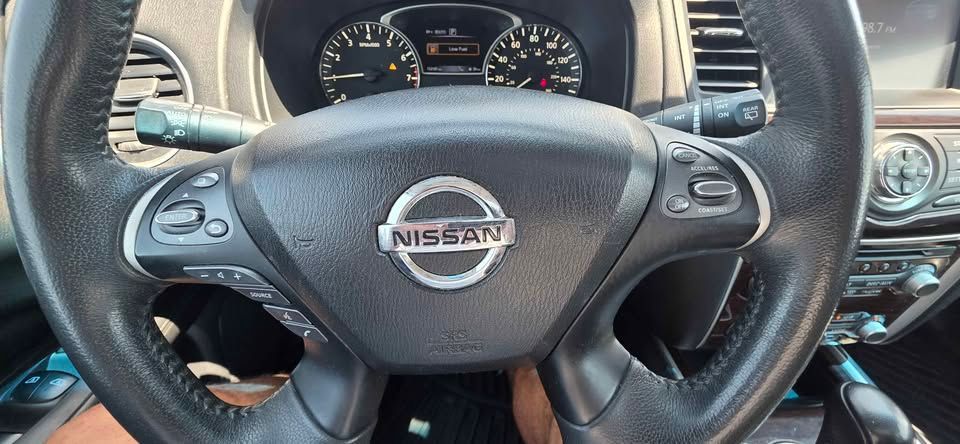 Nissan steering wheel and dashboard interior with black seats and wood trim