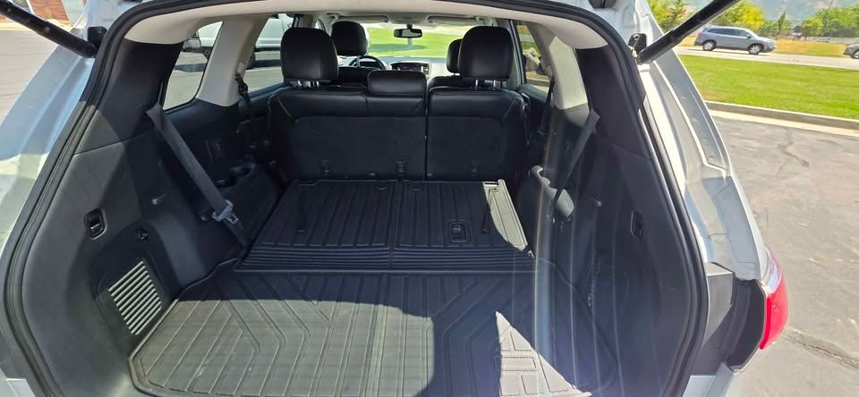 Open SUV cargo area with folded rear seats and black floor mats, viewed from the back.