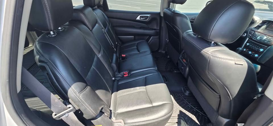 Black leather SUV rear seats folded down, showing a spacious cargo area with seat belts visible