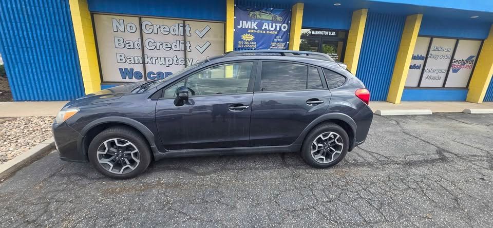 Dark gray SUV parked on a street in front of a blue storefront.