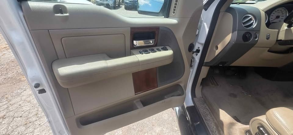 Open car door with beige panel and gray interior seats visible