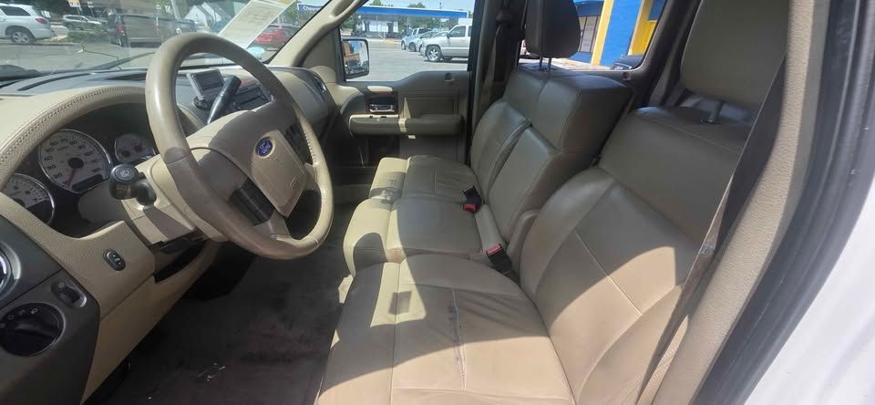 Tan interior of a car with front seats, steering wheel, and dashboard visible