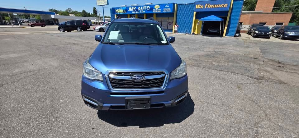 Blue SUV parked outside a car service center on a sunny day.