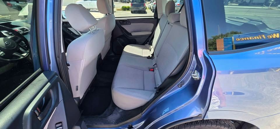 Open car door showing a gray interior with back seat and center console