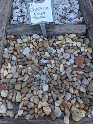 Small labeled display of rocks and pebbles, with a sign reading “Continental Creek Stone”
