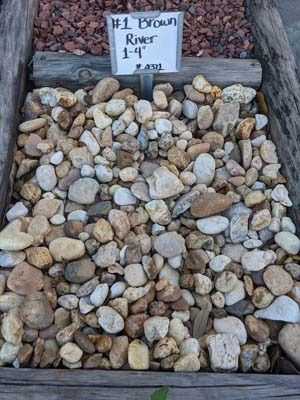 Stacked brown river rocks with a sign reading “#1 Brown River 1-4”