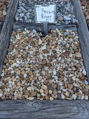 Two shallow trays of small pebbles labeled 