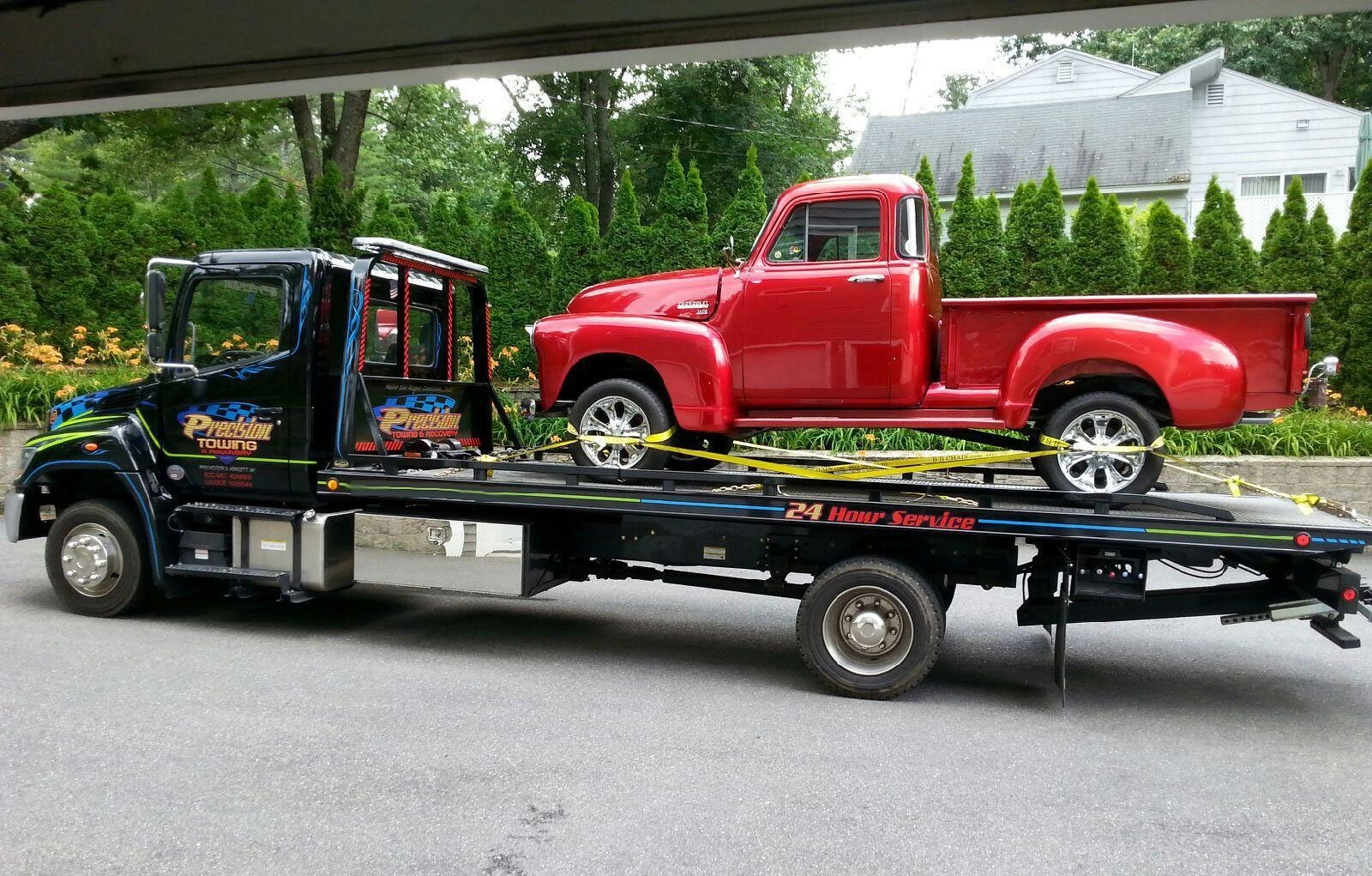 vintage red pickup truck being transported on flatbed