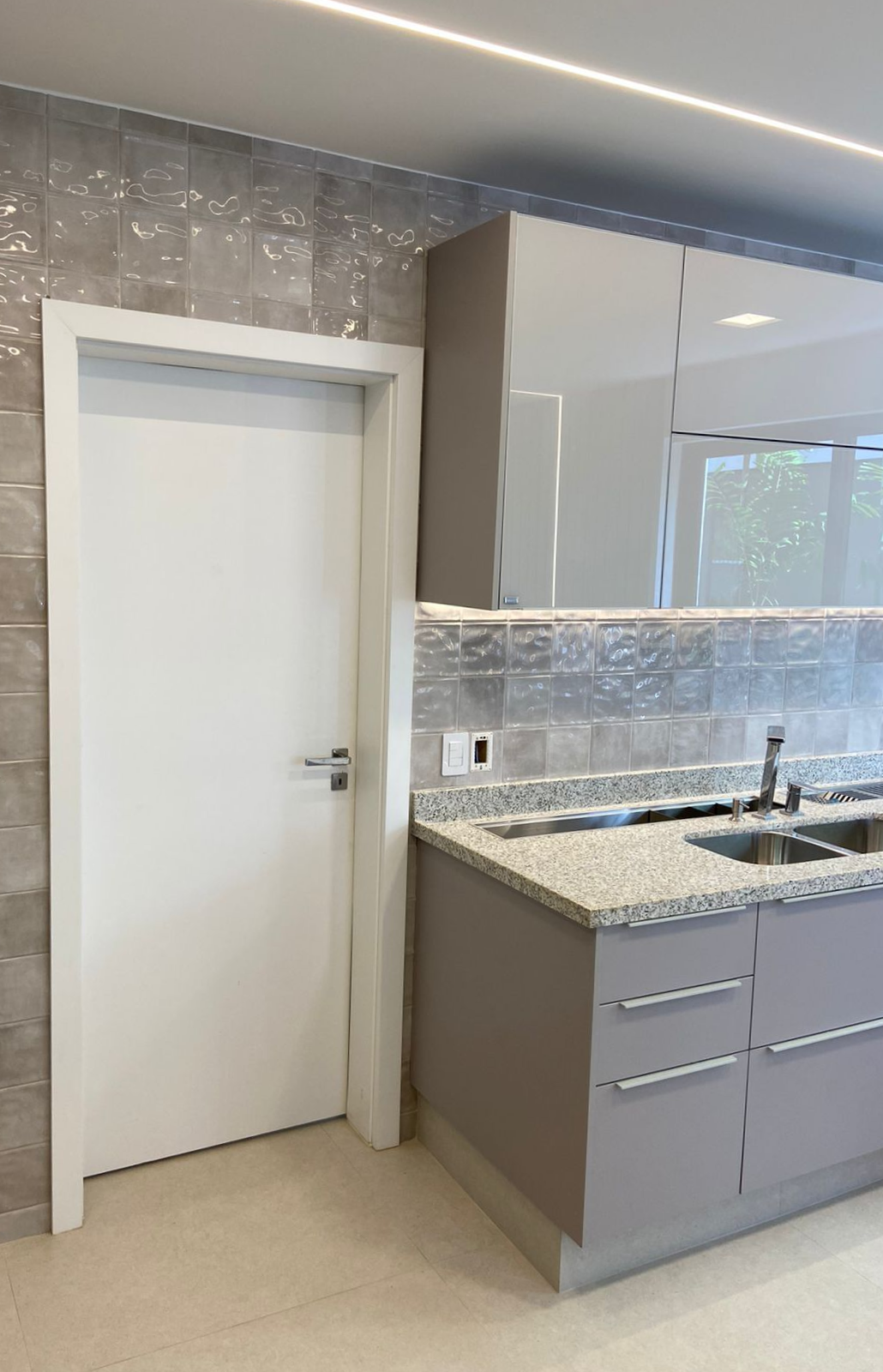 Uma cozinha com uma porta branca e uma pia