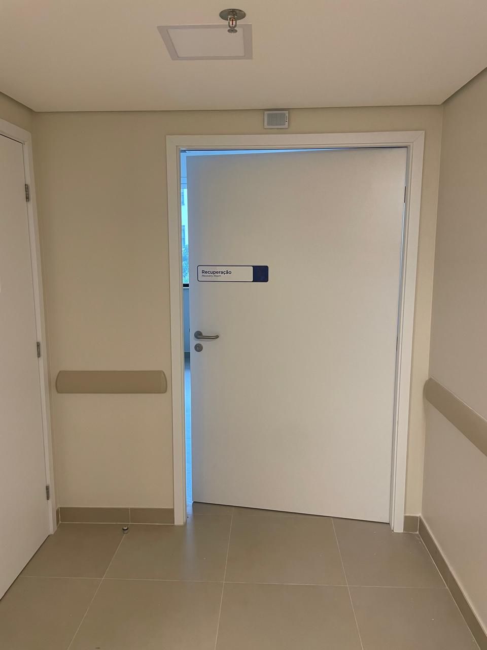 Um corredor com uma porta branca e uma placa que diz dr.