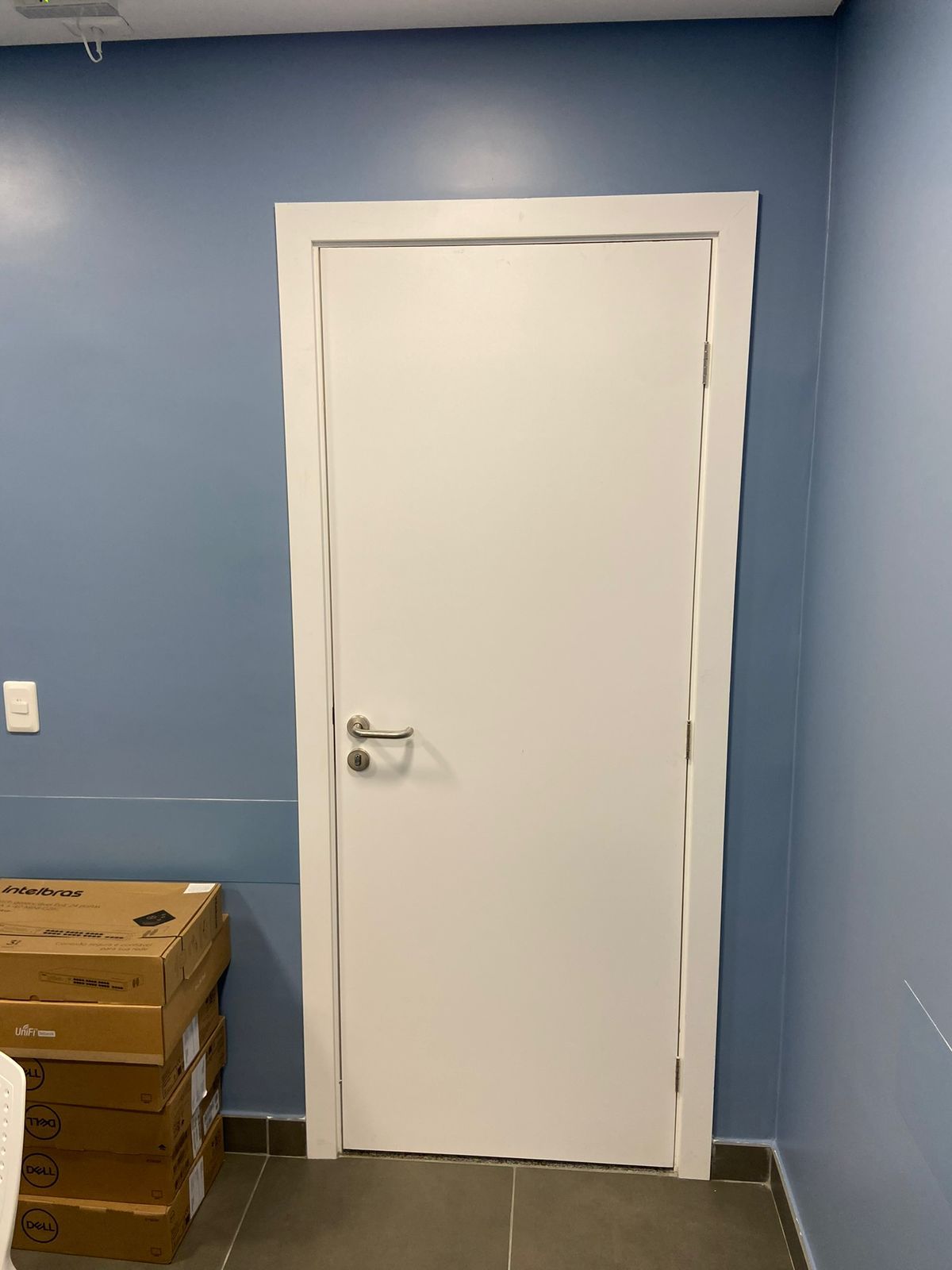 Uma porta branca em uma sala com paredes azuis