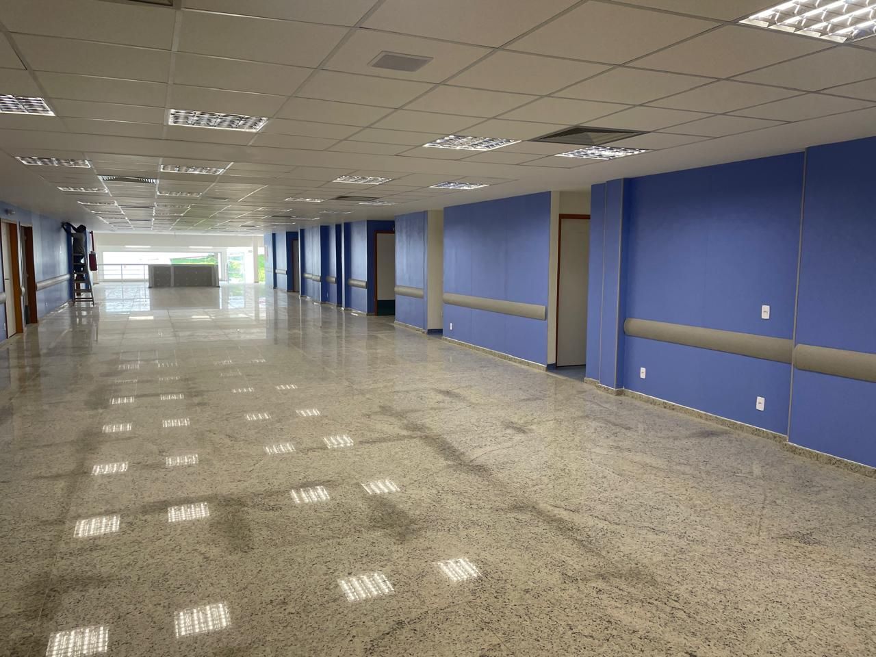 Um longo corredor com paredes azuis e tetos brancos