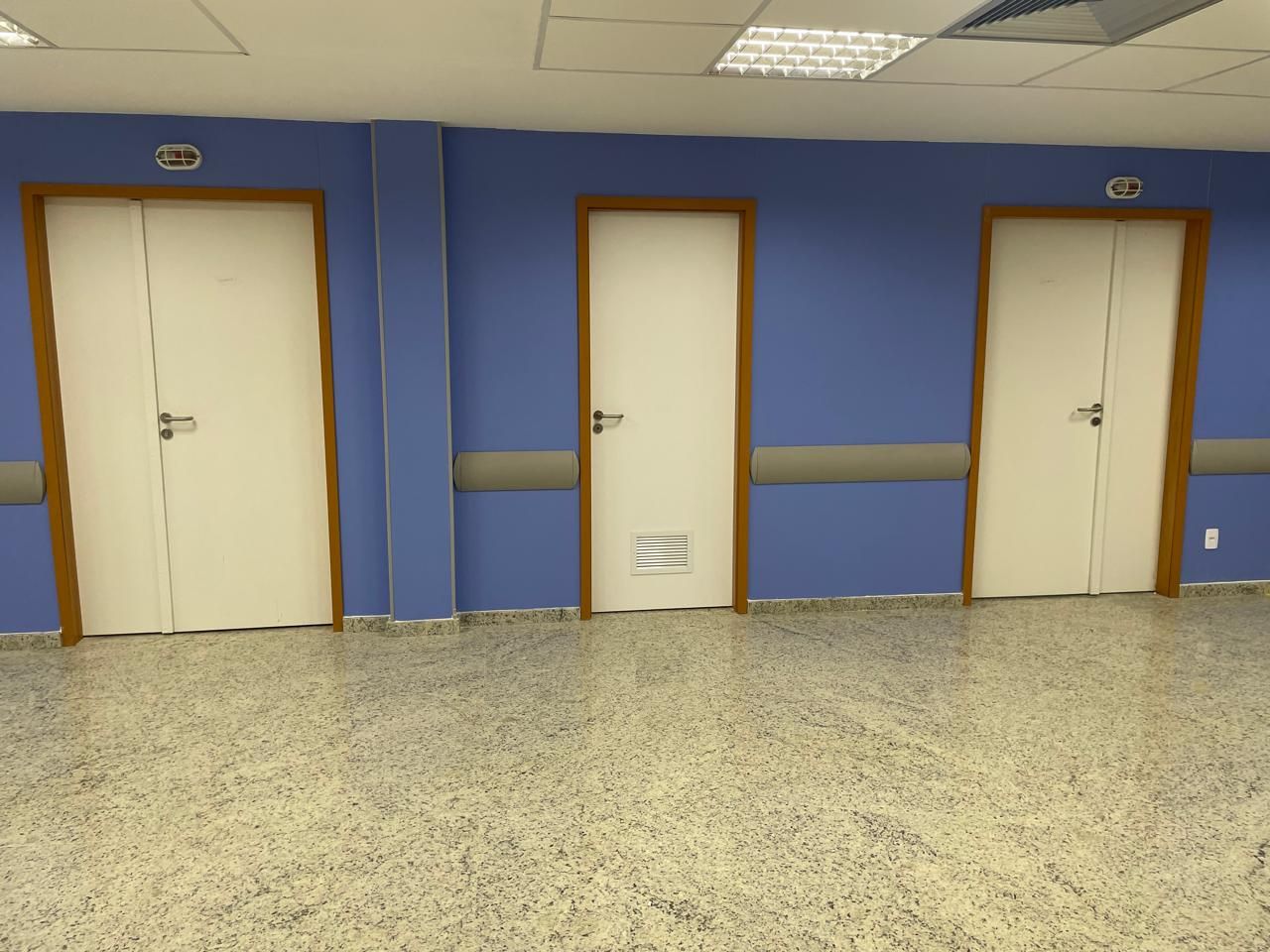 Um corredor com paredes azuis e portas brancas