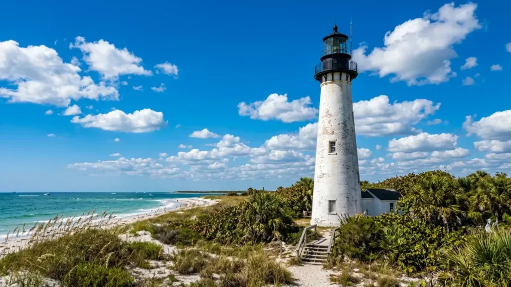 The historic Egmont Key lighthouse standing tall against a blue sky.