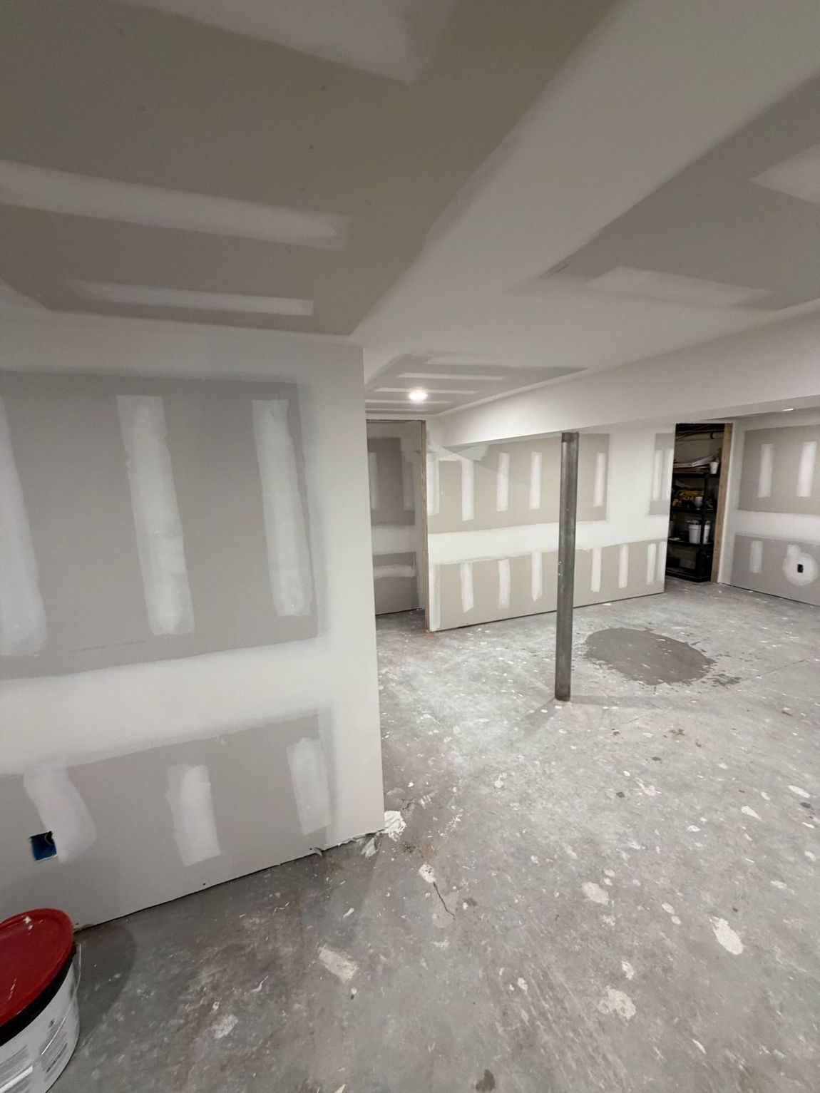An interior room under construction featuring unfinished drywall panels with taped seams on the walls and ceiling.