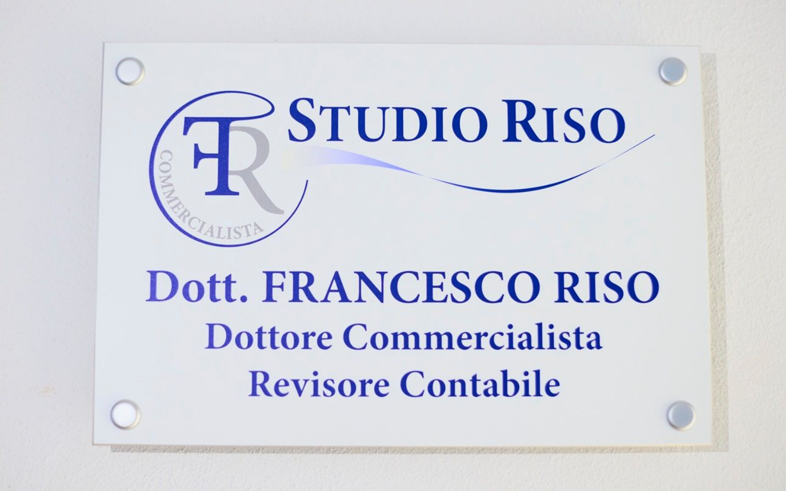 A sign for Studio Riso with the name Dott. Francesco Riso, Dottore Commercialista and Revisore Contabile in blue text.
