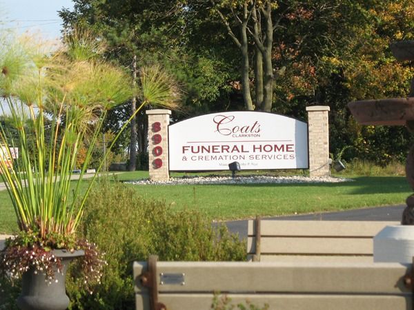 Coats Funeral Home sign in a landscaped outdoor area with benches and trees