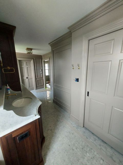 Custom finished shadow boxing painted to match custom cabinetry throughout master bath complete with pocket doors