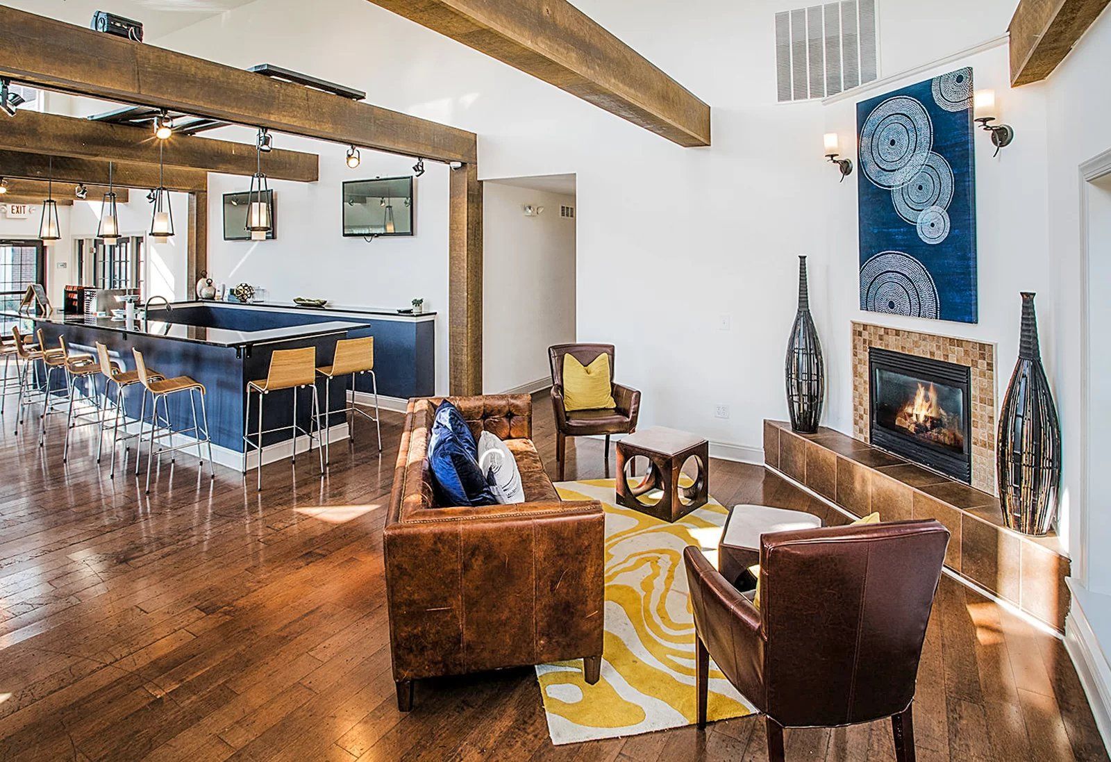 Spacious living area with hardwood floors, exposed beams, and a blue accent kitchen at Hamburg Farms in Lexington.