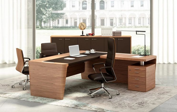 Elegante set da ufficio moderno con impiallacciatura in legno, laptop, sedie e un’ampia finestra affacciata su un edificio.