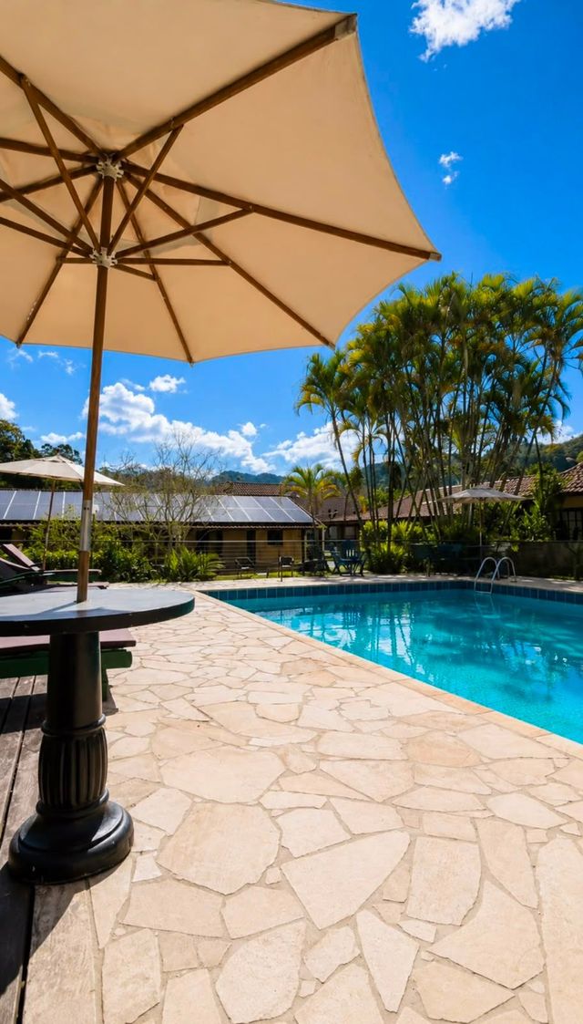 Uma grande piscina cercada por cadeiras e árvores