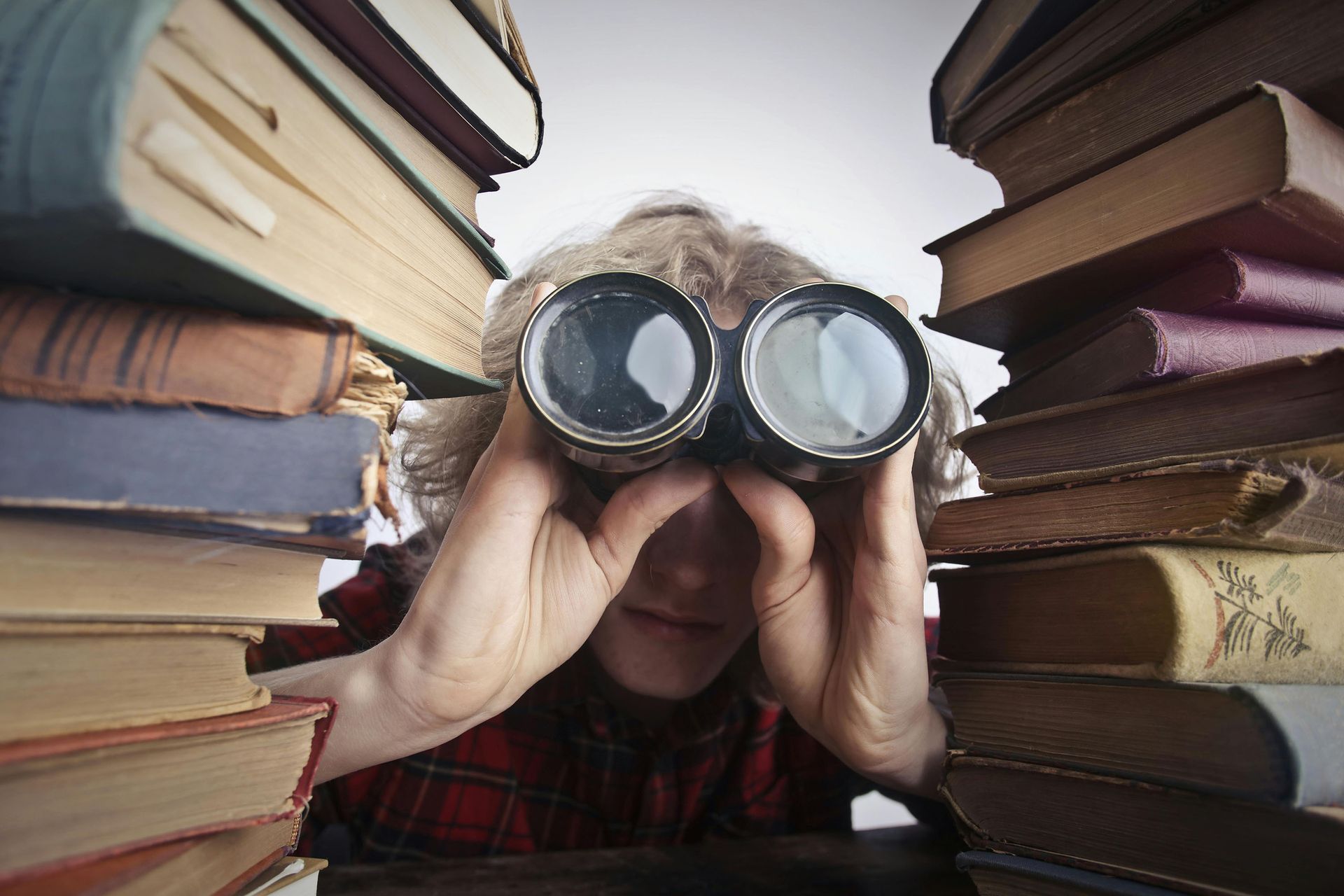 A man looking through binoculars to depict the concept of bad local web search and how to fix it.