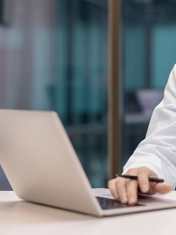 Person typing on a laptop at a desk in a modern office