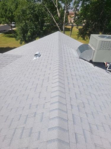 The roof of a house with a gray shingle roof