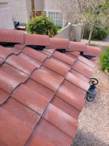 A red tile roof with a lamp hanging from it.