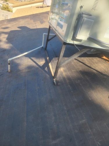 A piece of equipment is sitting on top of a roof.