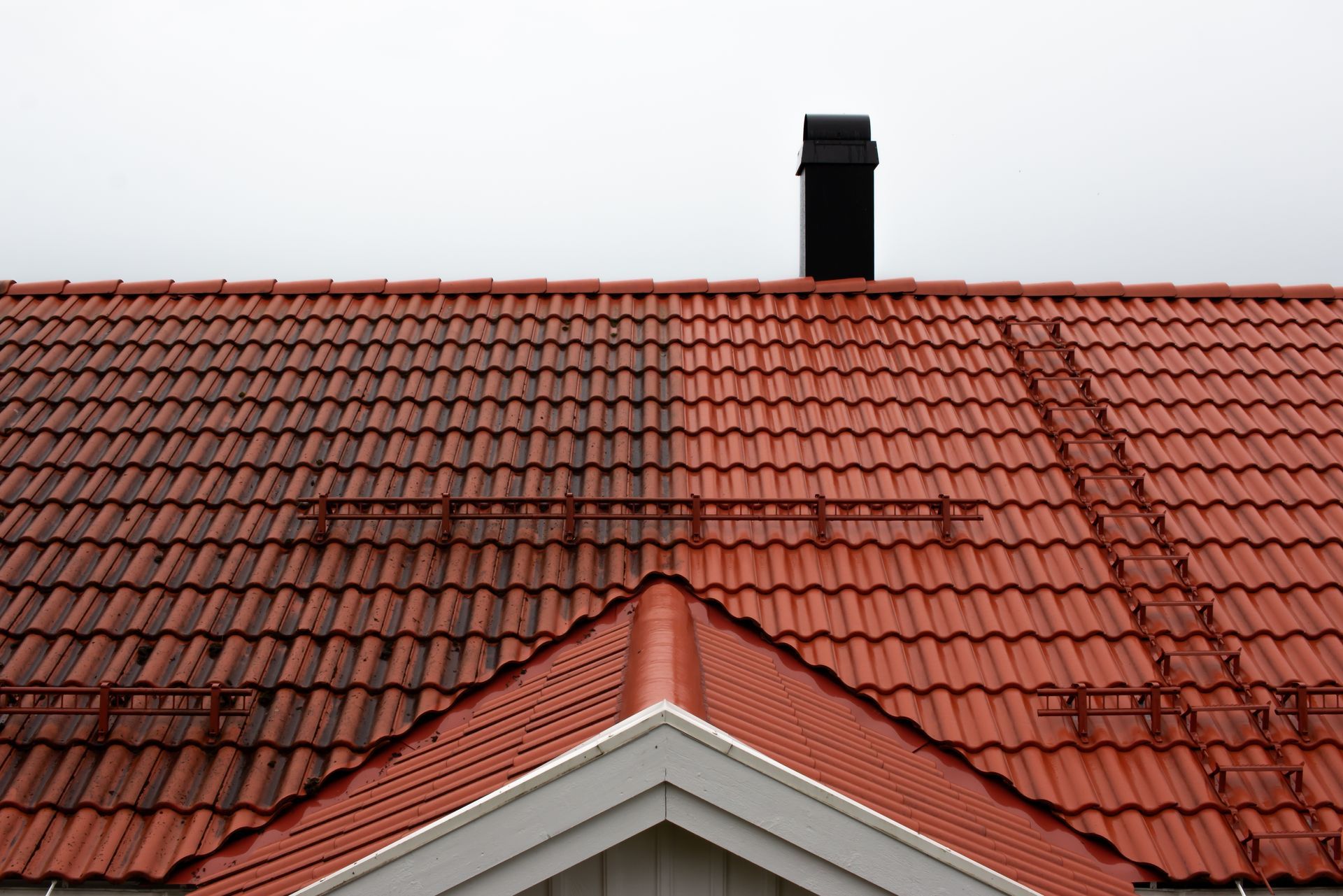 A red tiled roof with a chimney on top of it