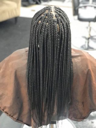 Box braids, dark hair flowing down back, salon setting.