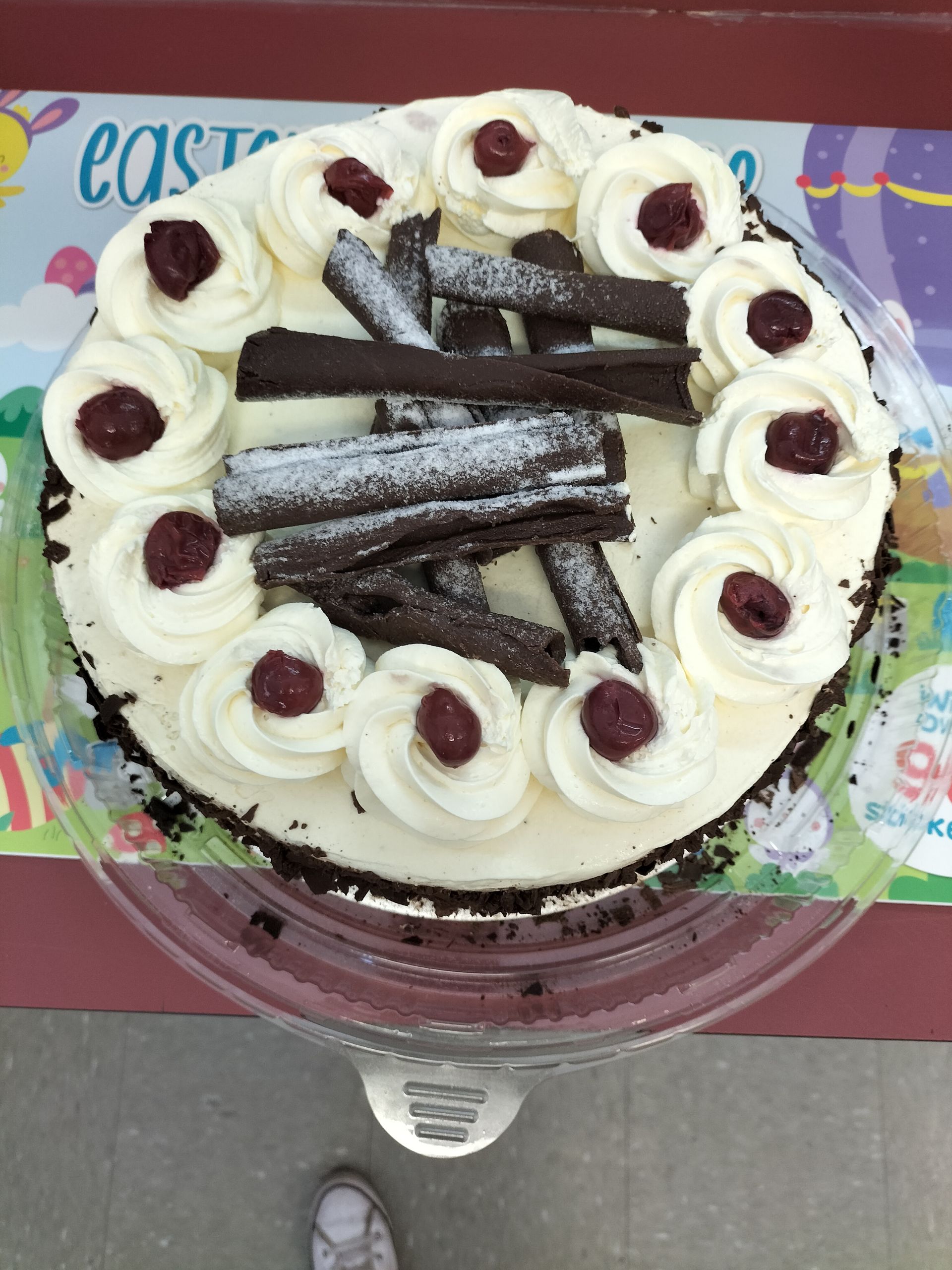 a cake with white frosting and cherries on it