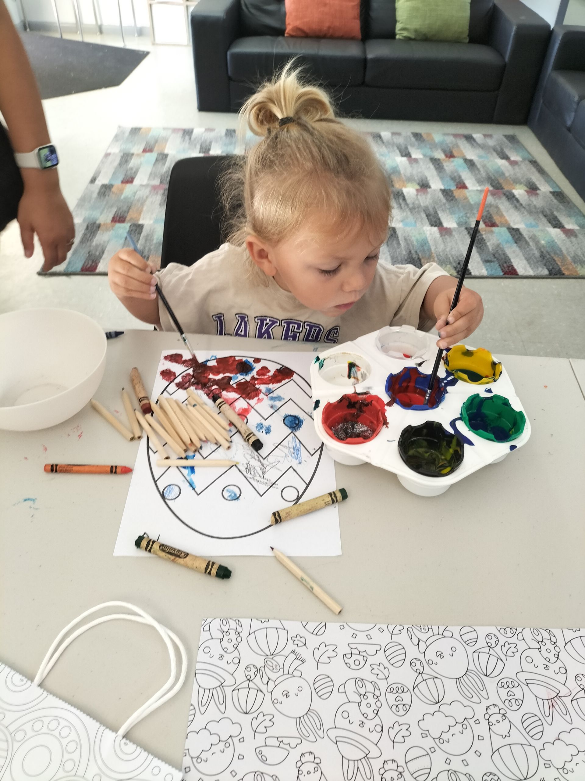 a little girl is sitting at a table painting