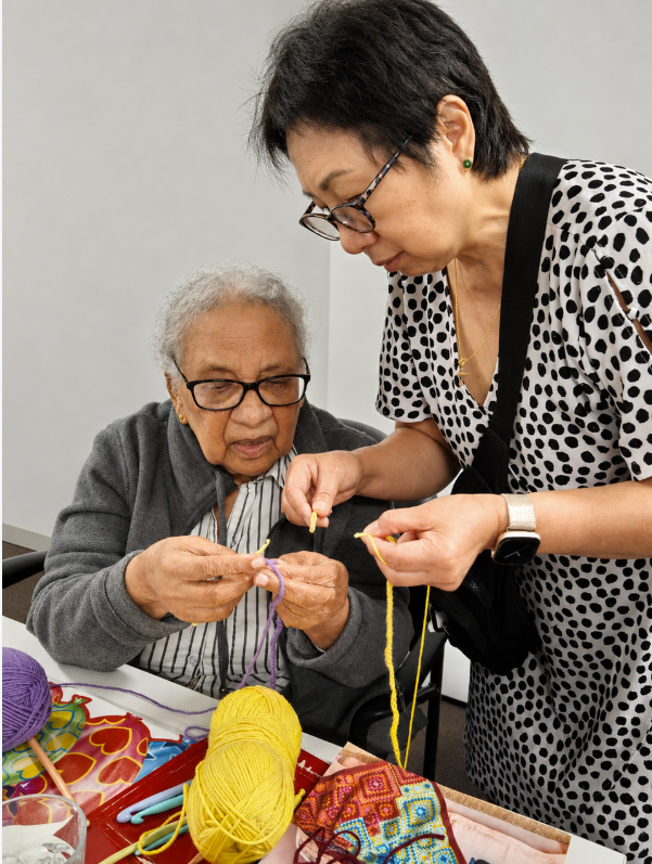 Two senior women knitting together at a Knitting, Sewing and Crochet Group session