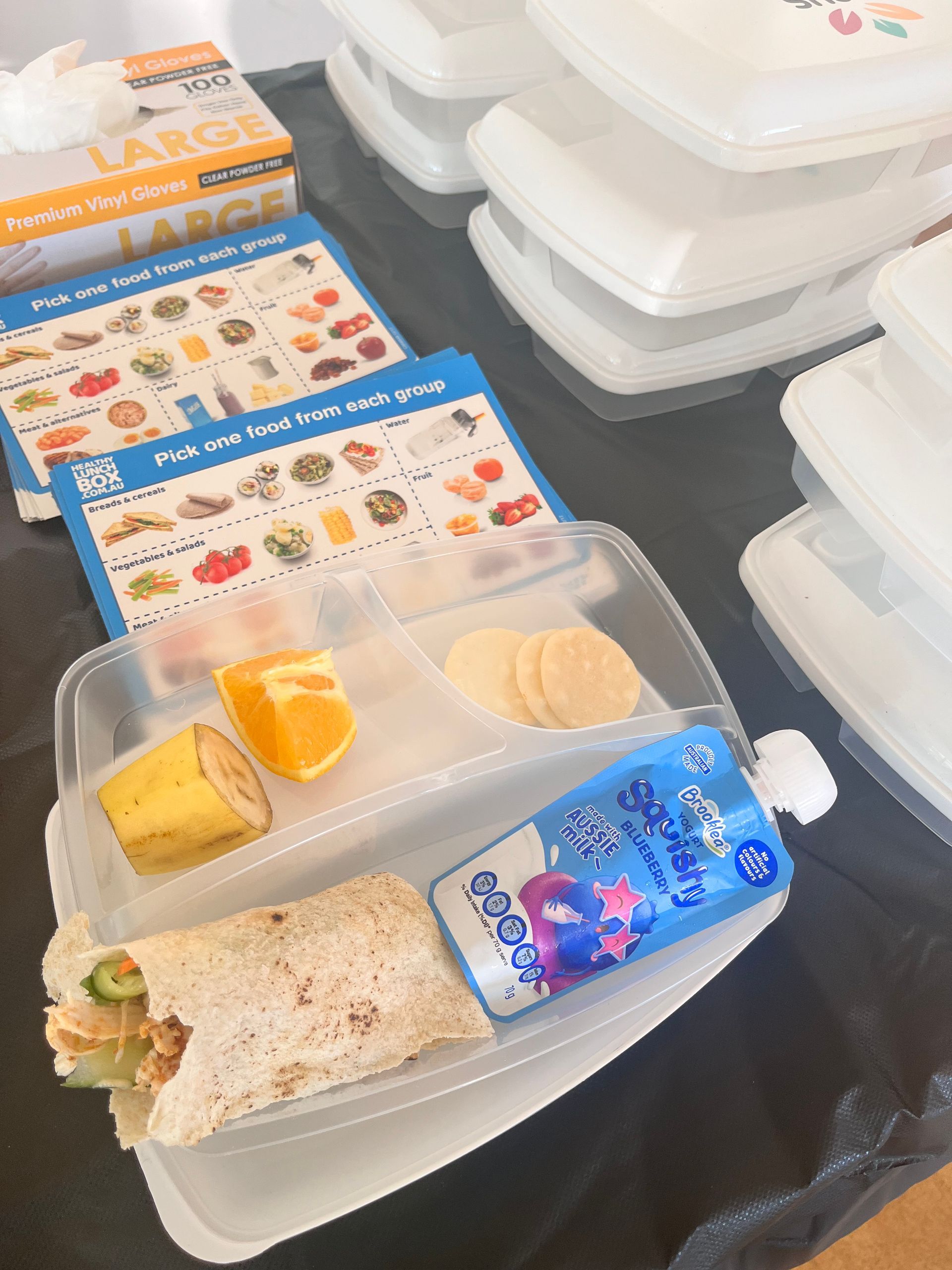 a lunch box with a wrap and a drink in it