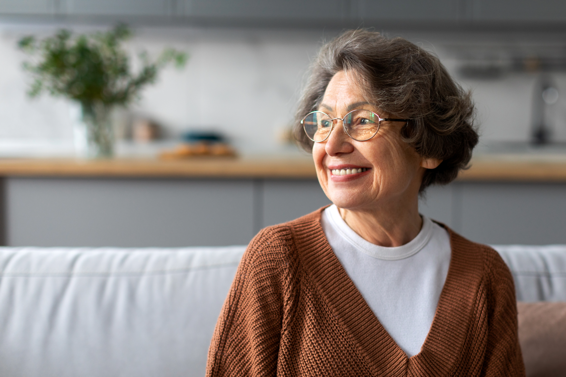 Smiling senior sitting on a sofa in a bright living room