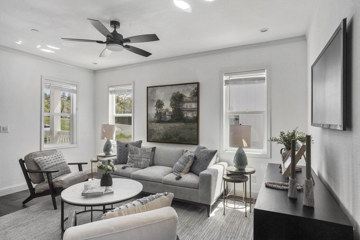Perpetual Homes ADU: Living room with a sofa, chairs, coffee table, art, and TV.