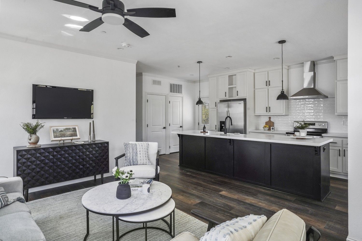 Perpetual Homes ADU: Modern open-concept living space with white walls, black cabinets, and hardwood floors. 