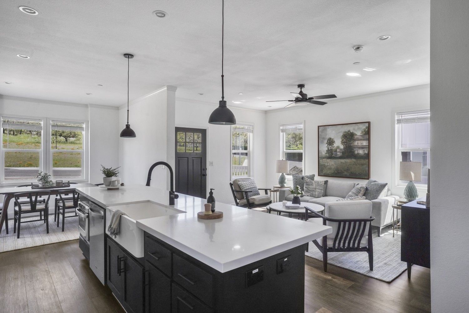 Perpetual Homes ADU: Open-concept kitchen and living room with dark cabinetry, white countertops, and hardwood floors.