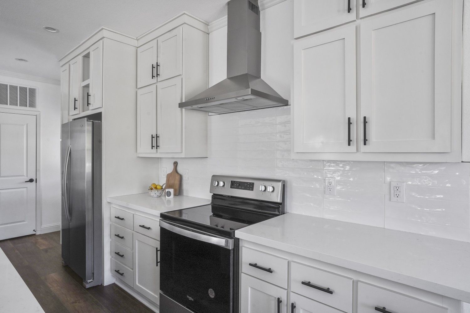 Perpetual Homes ADU: White kitchen with stainless steel appliances and cabinets.