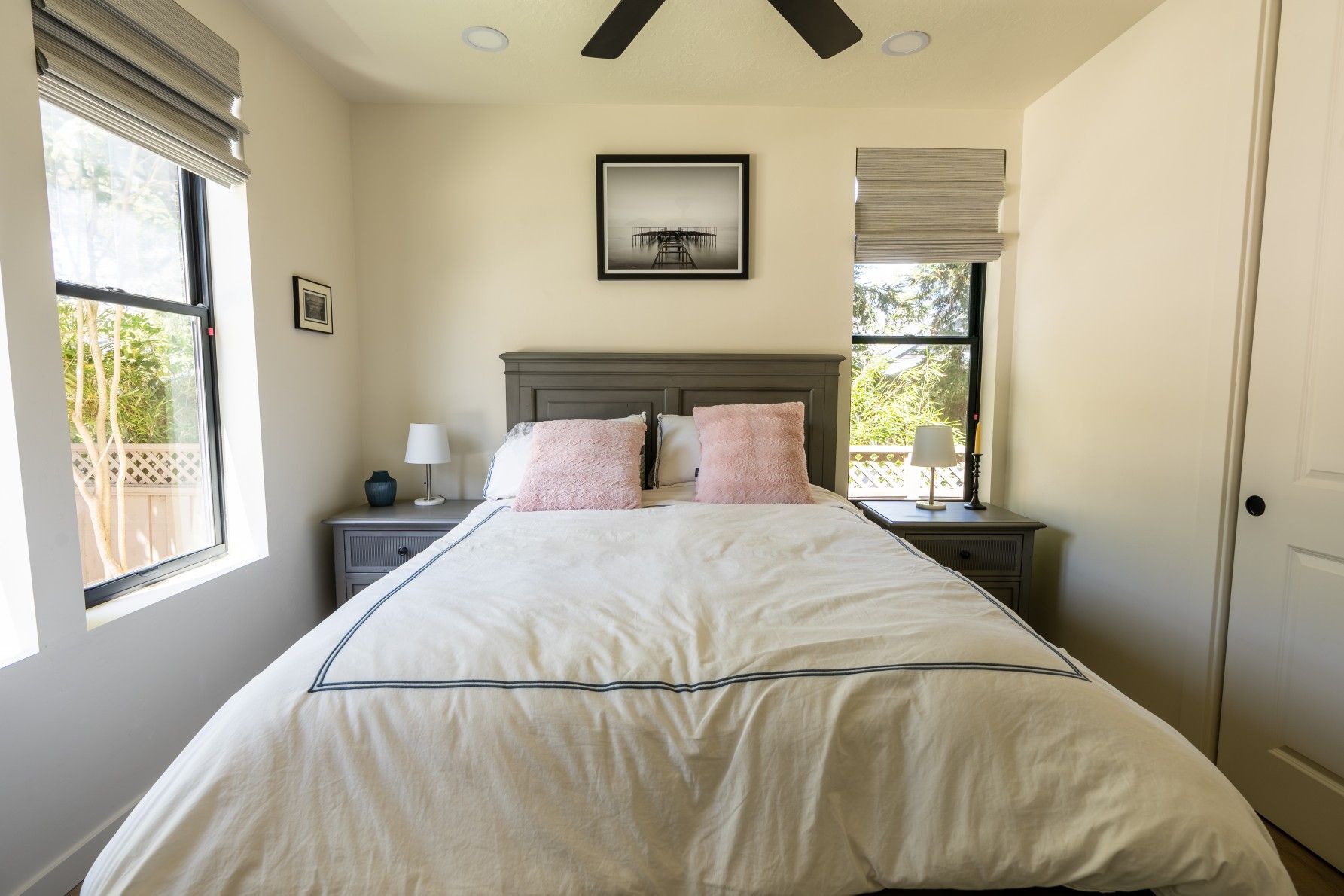 Perpetual Homes ADU: Bedroom with bed, nightstands, windows, and framed art. Beige walls, gray accents, and natural light.