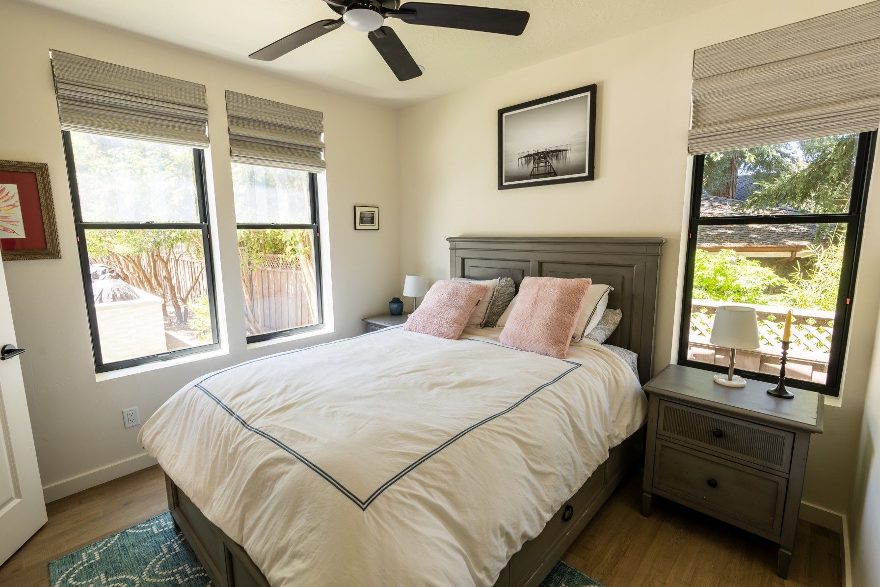 Perpetual Homes ADU: Bedroom with bed, windows, gray furniture, and decorative accents.