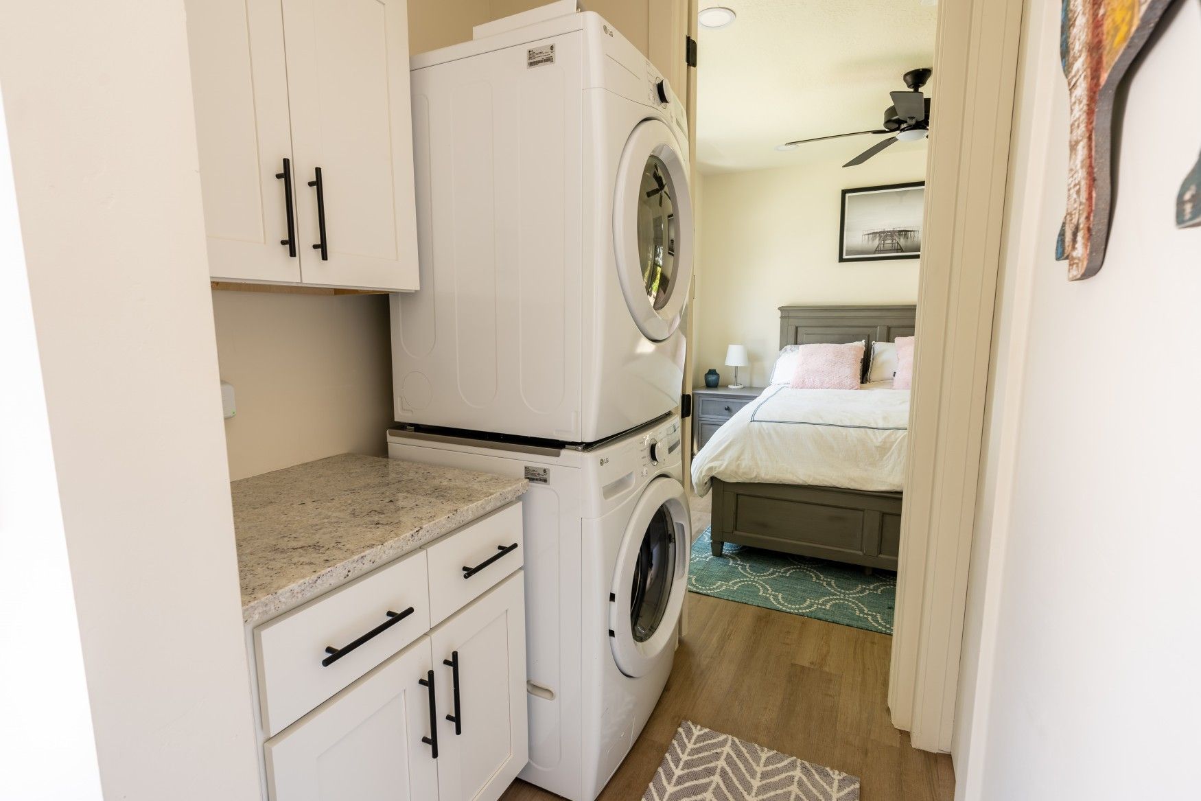 Perpetual Homes ADU: Stackable washer and dryer in a laundry room, with a glimpse of a bedroom.